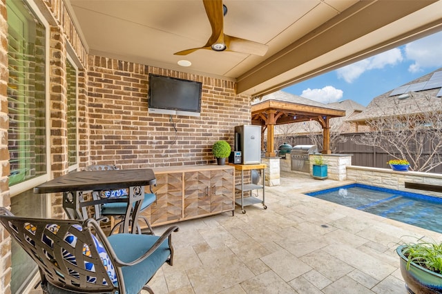 view of patio / terrace featuring a ceiling fan, an outdoor kitchen, area for grilling, a fenced backyard, and a gazebo