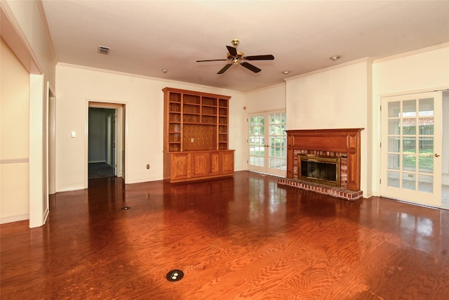 unfurnished living room with a fireplace, wood finished floors, visible vents, and crown molding