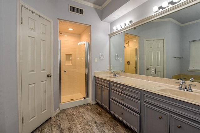 bathroom featuring ornamental molding, visible vents, a sink, and a shower stall