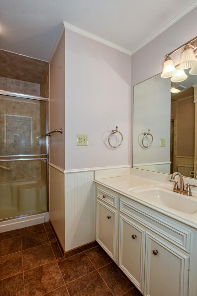 full bathroom with crown molding, wainscoting, a shower stall, vanity, and tile patterned flooring