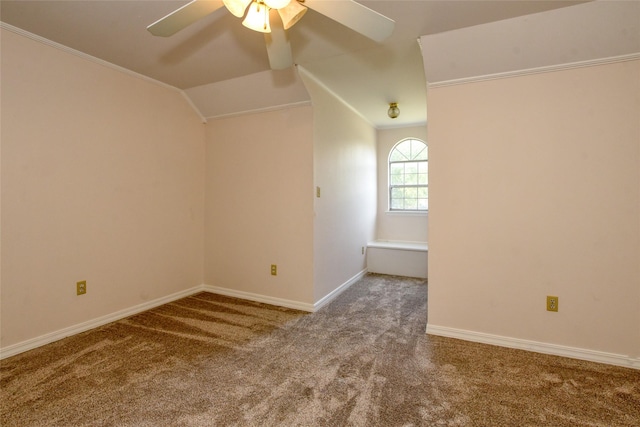 interior space with carpet floors, vaulted ceiling, baseboards, and a ceiling fan