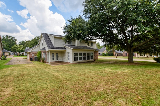 rear view of property with french doors and a yard