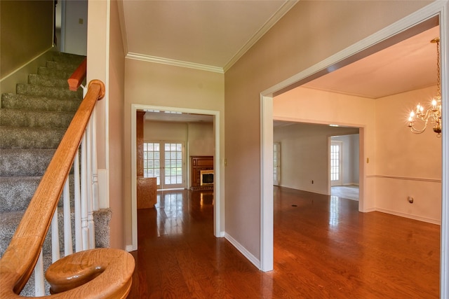 interior space featuring stairway, ornamental molding, wood finished floors, and an inviting chandelier