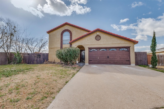 mediterranean / spanish house featuring driveway, a garage, fence, and stucco siding