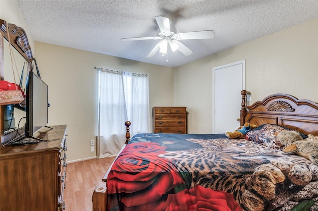 bedroom featuring a ceiling fan, a textured ceiling, and wood finished floors