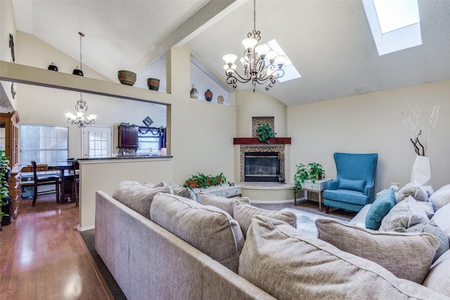 living room featuring a chandelier, a tile fireplace, dark wood-type flooring, and vaulted ceiling