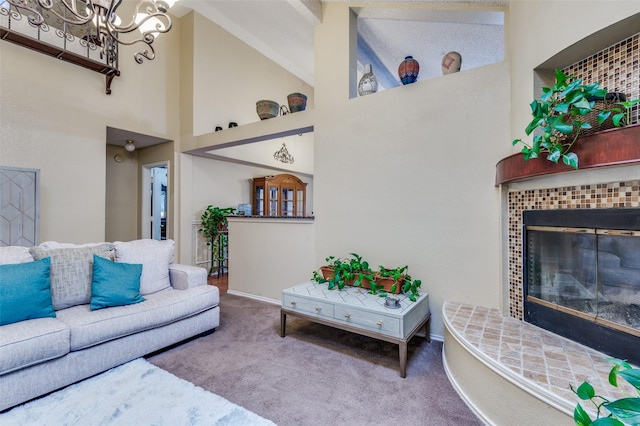 carpeted living area featuring a fireplace, a towering ceiling, and a notable chandelier