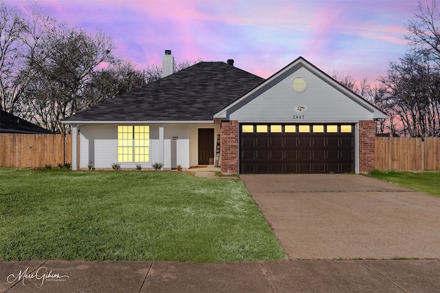 ranch-style home featuring an attached garage, concrete driveway, a front yard, and fence