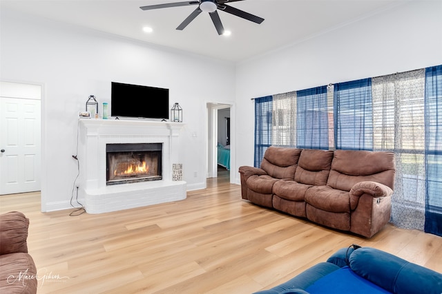 living area featuring recessed lighting, a ceiling fan, baseboards, light wood-type flooring, and a brick fireplace