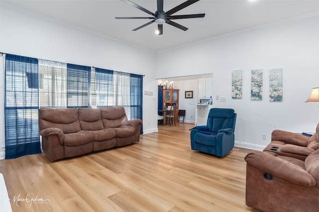 living room featuring light wood-style floors, ceiling fan, baseboards, and crown molding