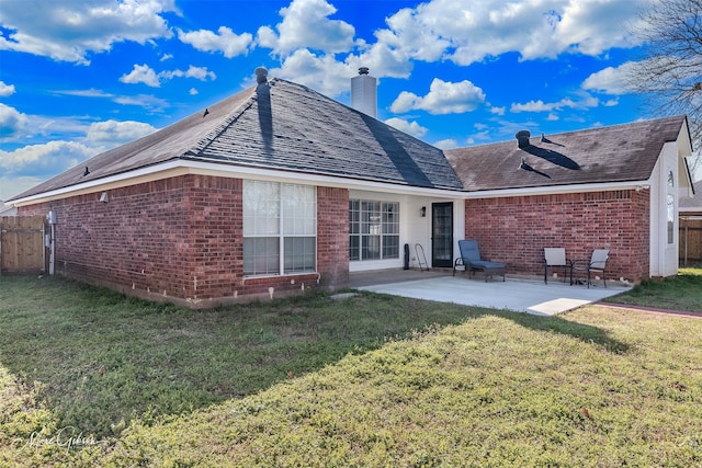 back of property featuring a patio area, a yard, fence, and brick siding