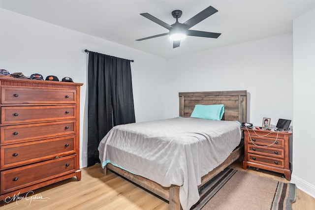 bedroom featuring ceiling fan, light wood finished floors, and baseboards