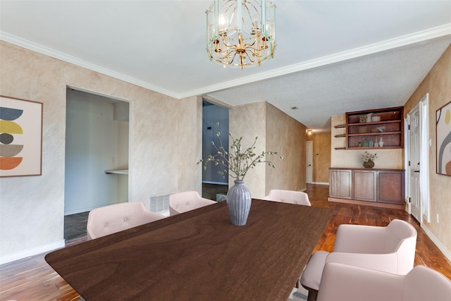 dining space featuring baseboards, wood finished floors, visible vents, and an inviting chandelier