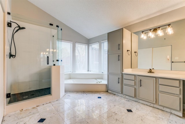 bathroom with a textured ceiling, vanity, vaulted ceiling, a shower stall, and a bath