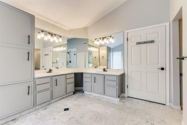 bathroom featuring marble finish floor, lofted ceiling, vanity, a textured ceiling, and a shower stall