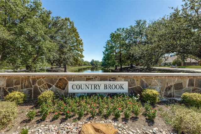 community / neighborhood sign featuring a water view