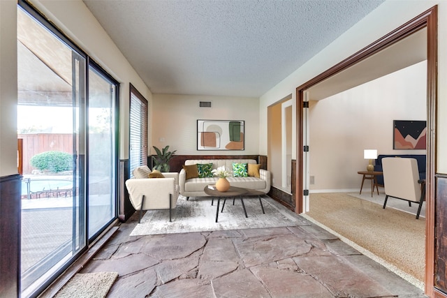 interior space with stone finish floor, baseboards, visible vents, and a textured ceiling