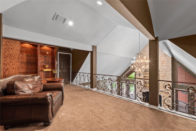 sitting room with carpet, vaulted ceiling, visible vents, and a chandelier