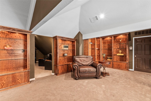 sitting room featuring vaulted ceiling, carpet, and visible vents