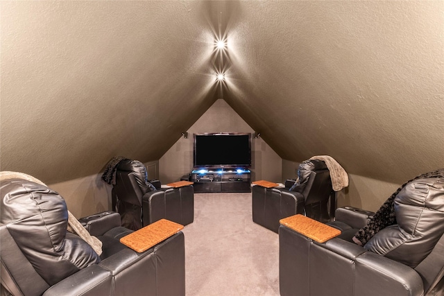 carpeted home theater room featuring vaulted ceiling and a textured ceiling