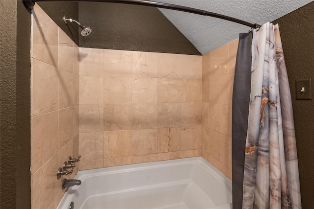 full bath with a textured ceiling, a textured wall, vaulted ceiling, and shower / bath combo with shower curtain