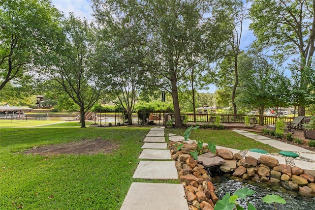 view of community with fence and a yard