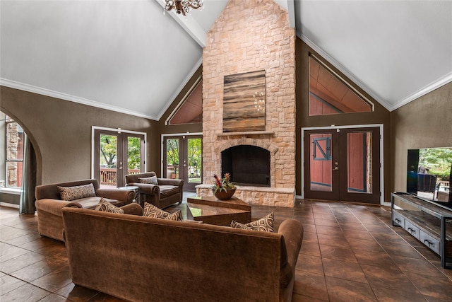 living area with ornamental molding, arched walkways, french doors, and a stone fireplace