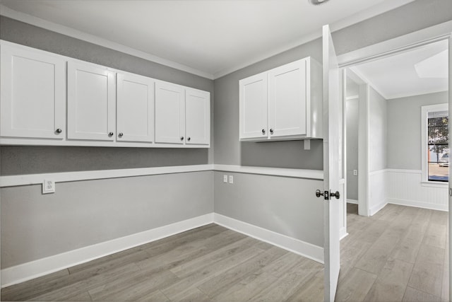 laundry area featuring light wood-type flooring, baseboards, ornamental molding, and wainscoting