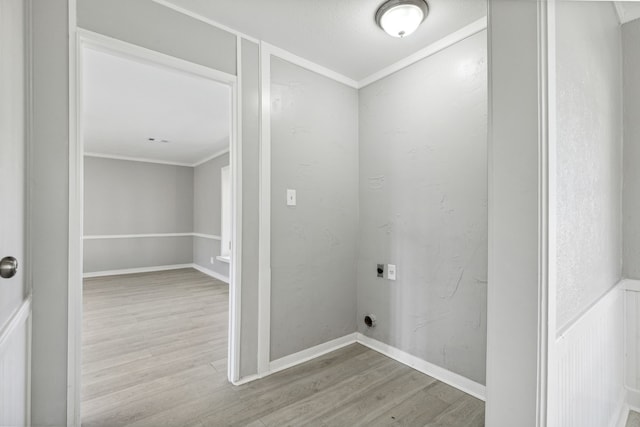 laundry area with laundry area, crown molding, electric dryer hookup, and wood finished floors