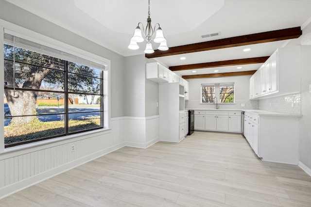 interior space with light wood-style flooring, visible vents, beamed ceiling, and wainscoting