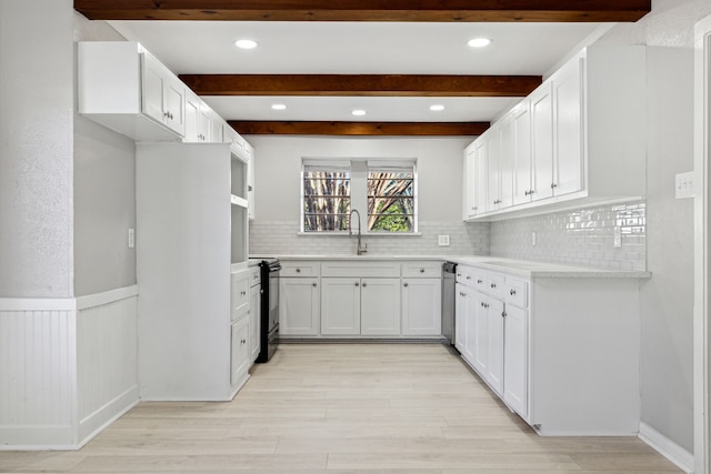 kitchen with black / electric stove, a sink, and beamed ceiling