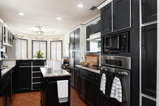 kitchen with black appliances, visible vents, dark cabinetry, and recessed lighting