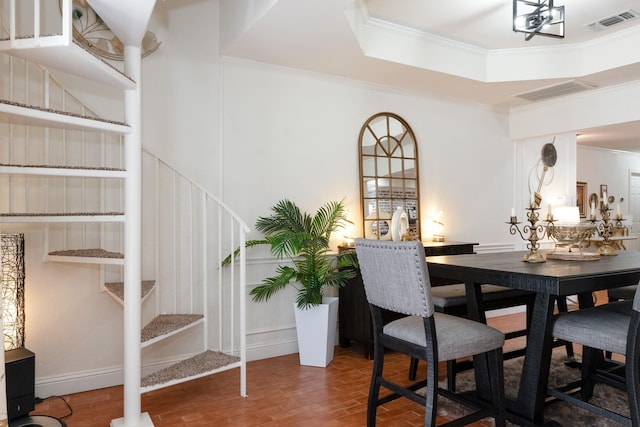 dining room with visible vents, a raised ceiling, ornamental molding, wood finished floors, and stairs