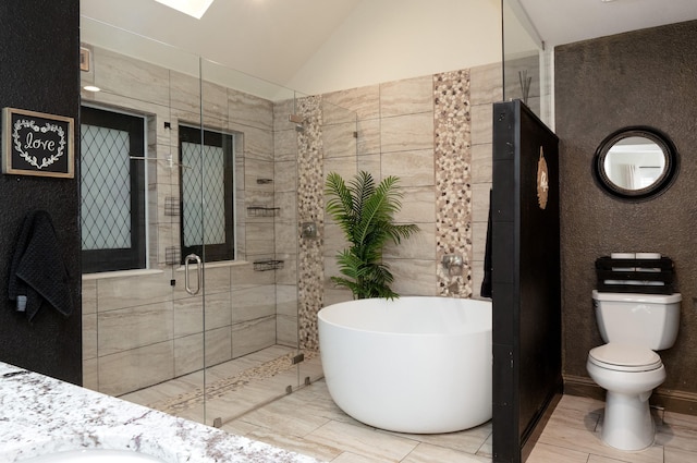 bathroom featuring tile walls, lofted ceiling, a freestanding bath, toilet, and a stall shower