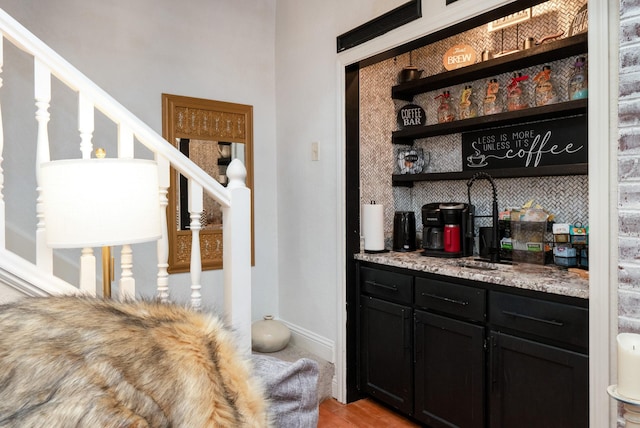 bar with light wood-style flooring, baseboards, and stairs