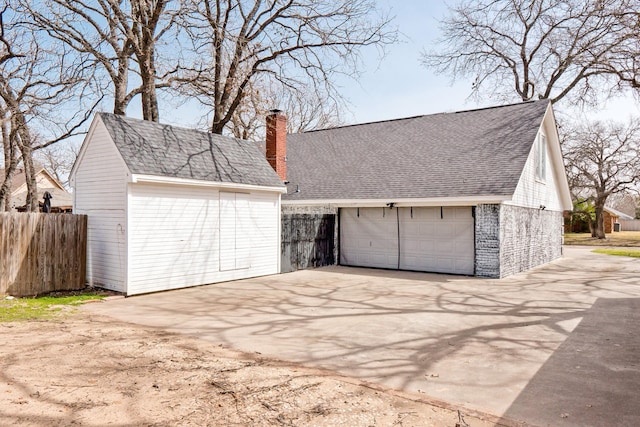 detached garage featuring fence