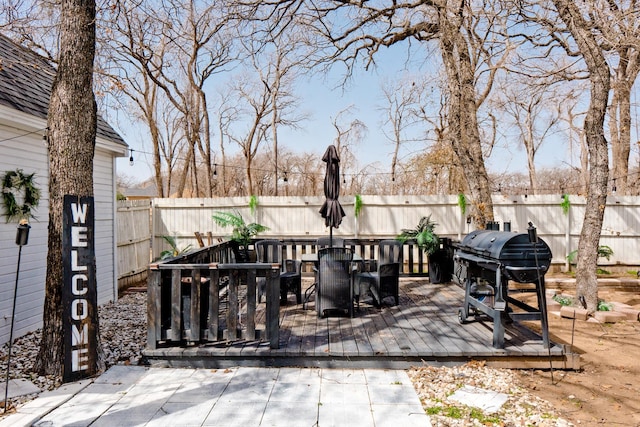 view of patio featuring a fenced backyard, a grill, and a deck