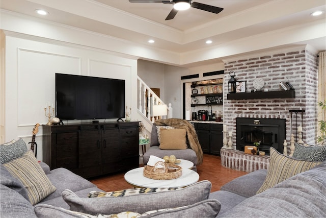 living room featuring crown molding, recessed lighting, a raised ceiling, stairway, and wood finished floors