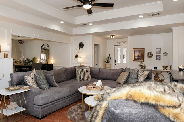 living room featuring ornamental molding, a tray ceiling, visible vents, and recessed lighting