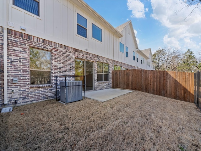 rear view of house featuring central AC, brick siding, board and batten siding, and fence