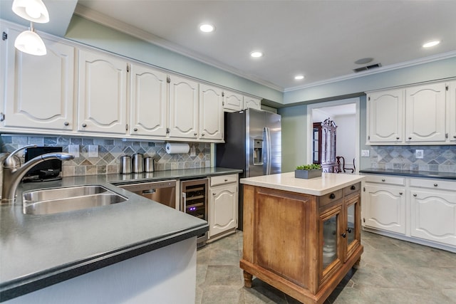 kitchen featuring a sink, wine cooler, crown molding, white cabinetry, and recessed lighting