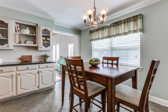 dining area with crown molding and a notable chandelier