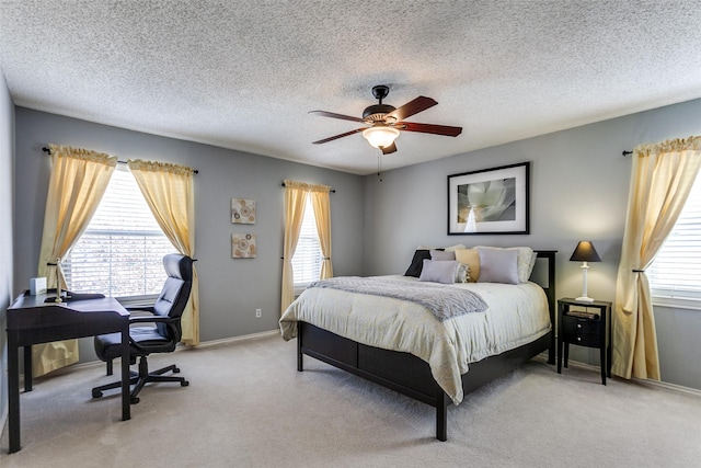 bedroom featuring a ceiling fan, light colored carpet, a textured ceiling, and baseboards