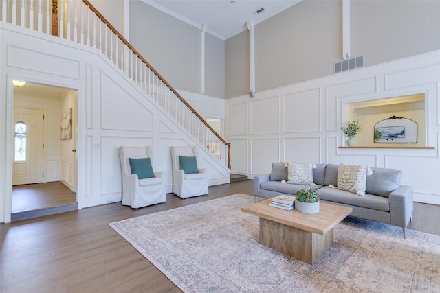 13 Gettysburg Ln, Richardson, TX 75080 - living room with a decorative wall, a high ceiling, ornamental molding, wood finished floors, and stairs