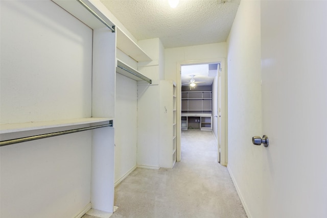 spacious closet featuring light carpet and a ceiling fan