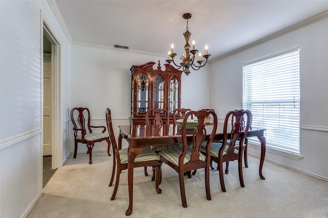 dining room featuring crown molding, visible vents, light carpet, a chandelier, and baseboards