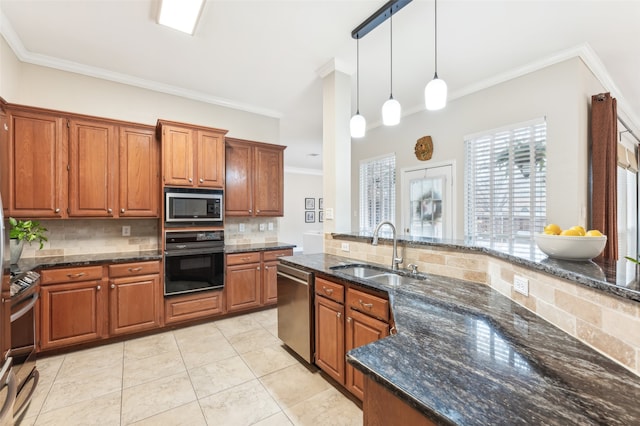 kitchen featuring stainless steel appliances, brown cabinets, a sink, and ornamental molding