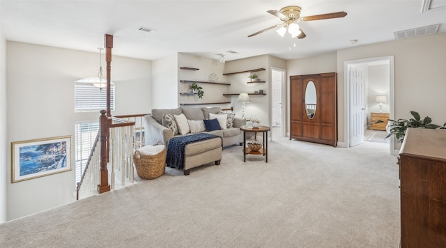 living room featuring light carpet, visible vents, and a ceiling fan