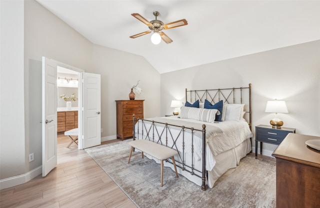 bedroom with ceiling fan, connected bathroom, baseboards, vaulted ceiling, and light wood-type flooring