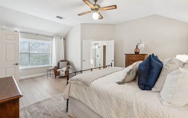 bedroom with visible vents, vaulted ceiling, baseboards, and wood finished floors